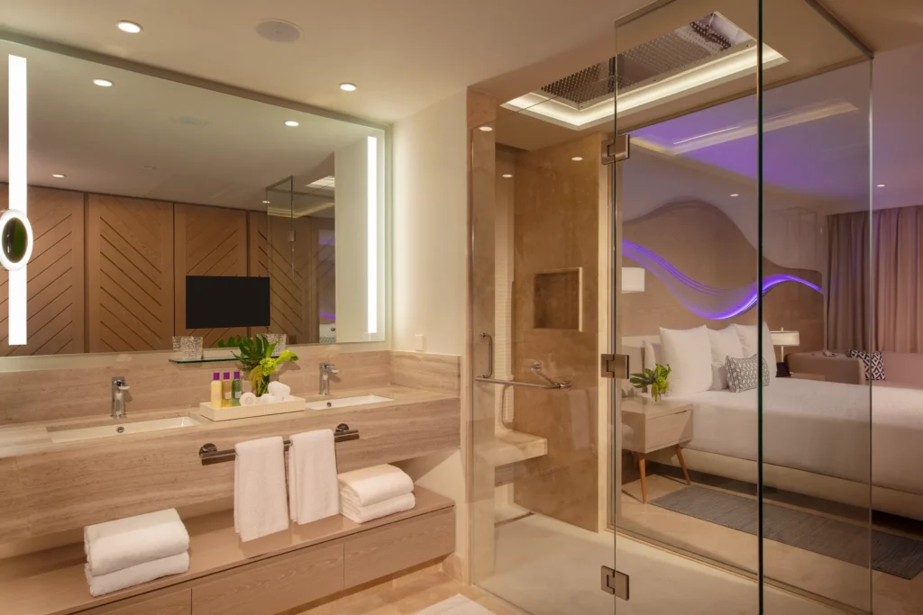 Luxury bathroom in the Xhale Club Junior Suite Upper Ocean Front at Breathless Cancun Soul Resort with double vanity and glass shower.