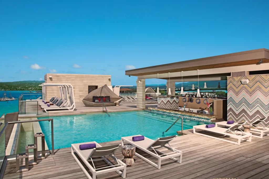 Altitude rooftop pool and bar at Breathless Montego Bay overlooking turquoise Caribbean waters.