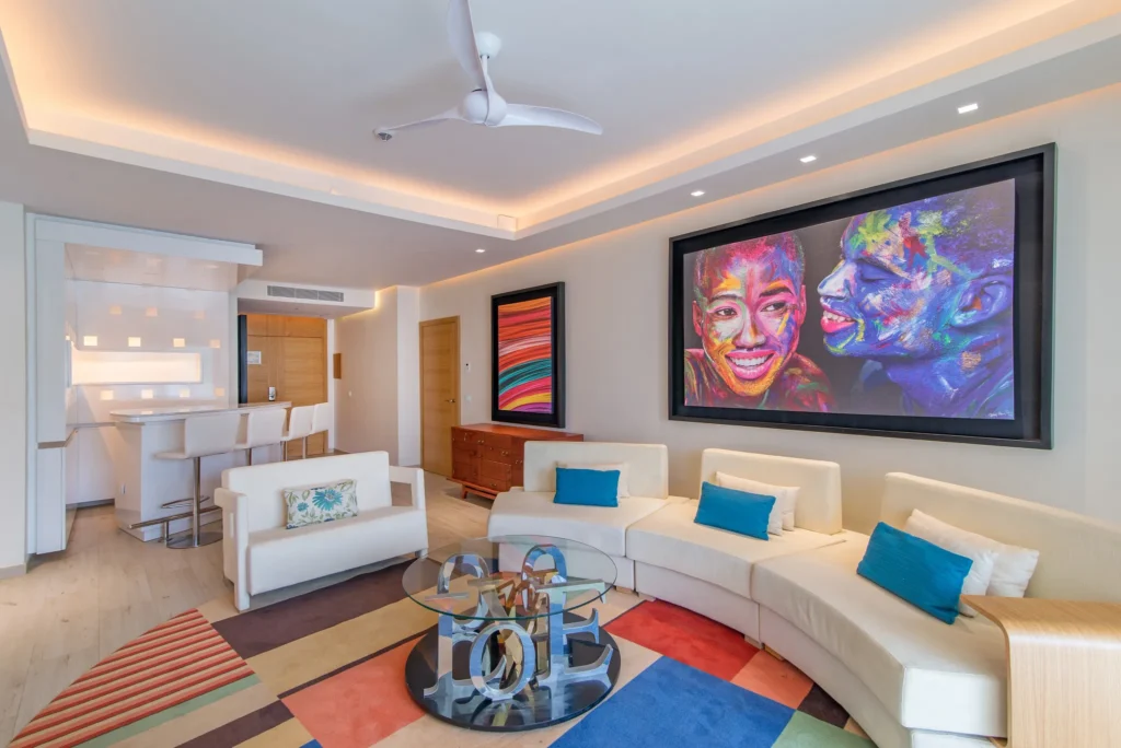 Xhale Club Master Suite Swim-Up living room at Breathless Montego Bay with modern seating area, large wall art, entertainment center, and open-concept layout.