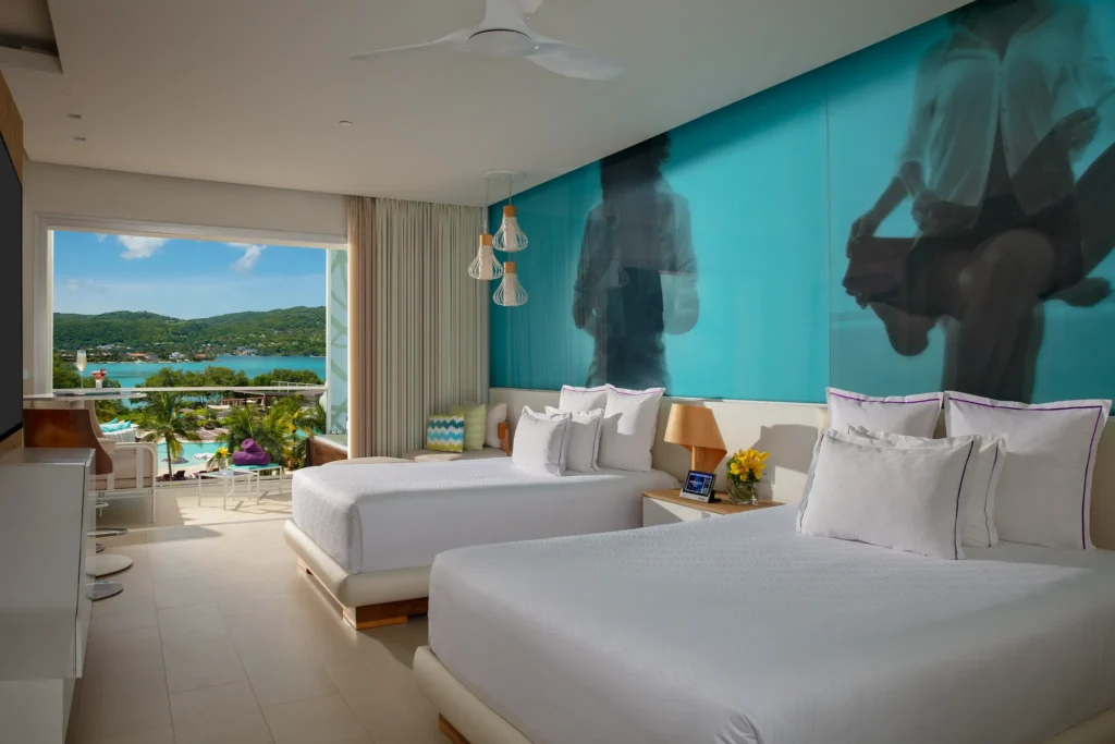 Allure Junior Suite Ocean View double-bed layout at Breathless Montego Bay overlooking the bay and resort pool.