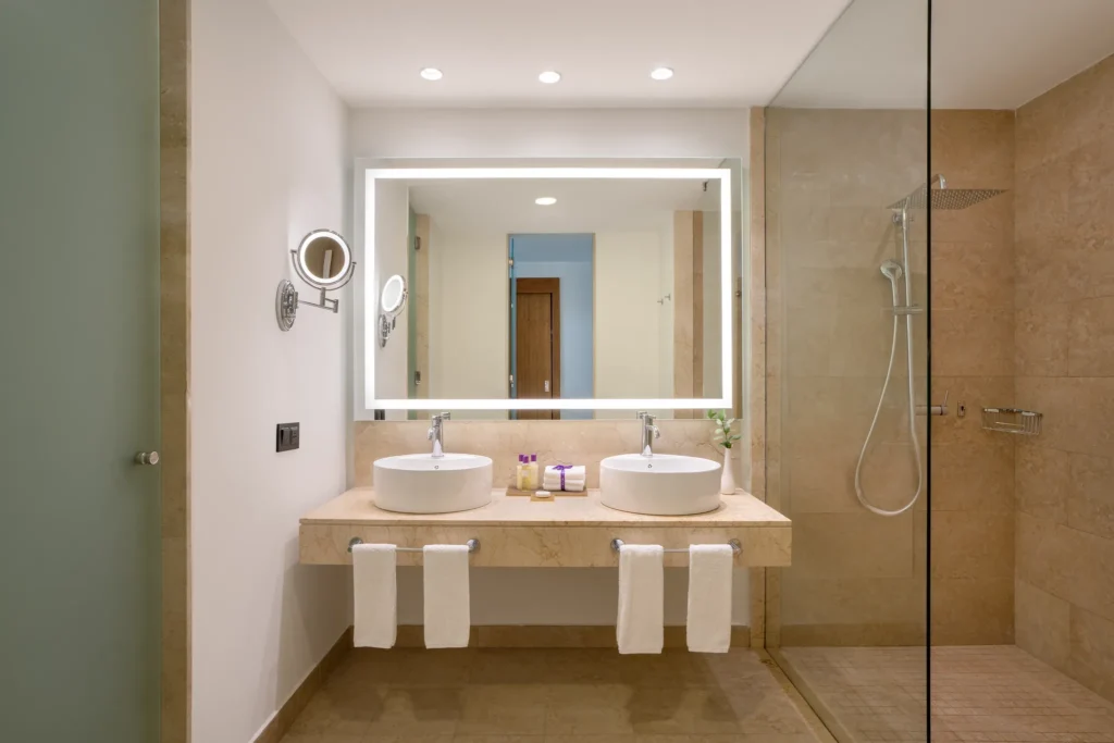 Allure Junior Suite bathroom with double vanity and glass-enclosed shower at Breathless Punta Cana Resort.