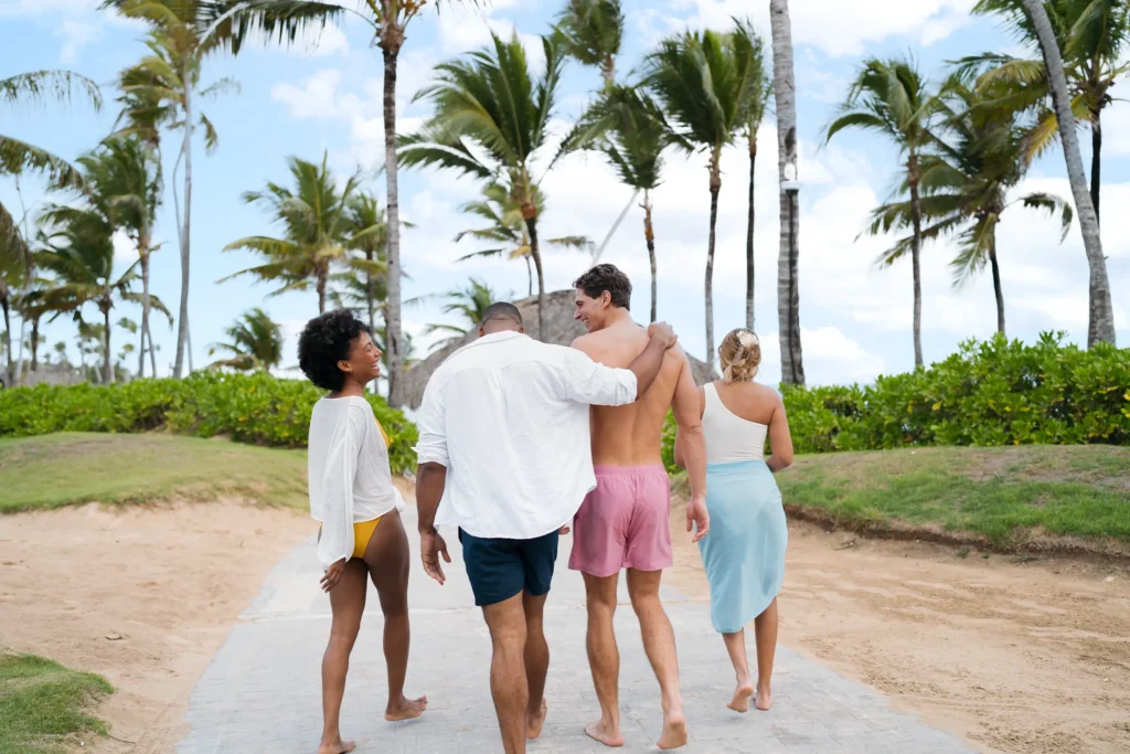 Friends walking through palm-lined pathways at Breathless Punta Cana Resort.