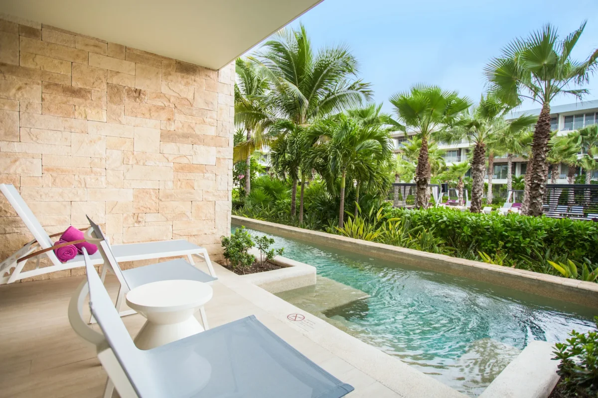 Xcelerate Junior Suite Swim Out Tropical View terrace at Breathless Riviera Cancun with private swim-out pool, lounge chairs, and lush tropical garden views.