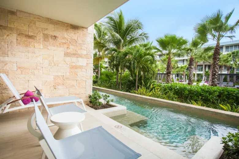 Xcelerate Junior Suite Swim Out Tropical View terrace at Breathless Riviera Cancun with private swim-out pool, lounge chairs, and lush tropical garden views.