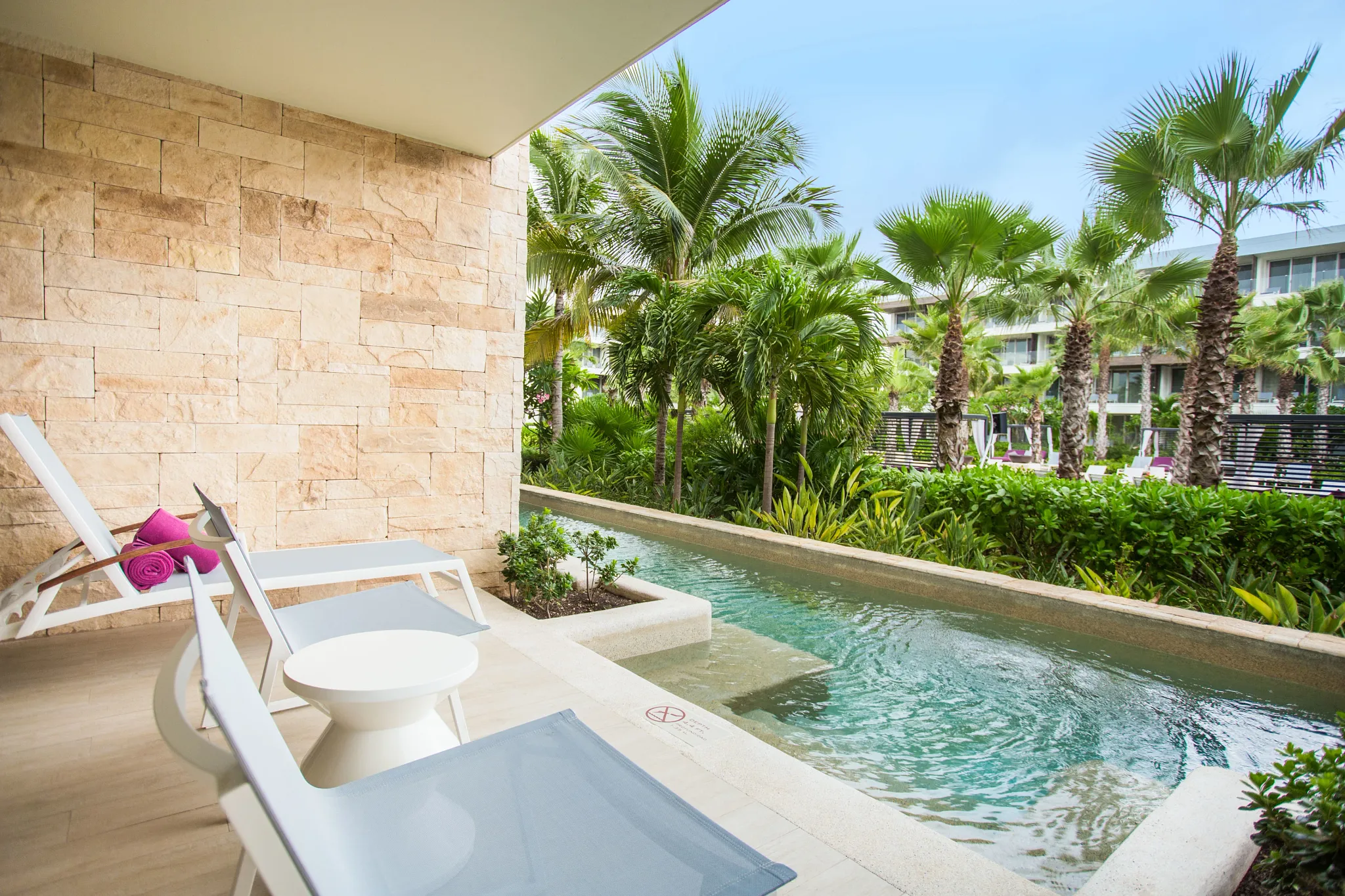 Xcelerate Junior Suite Swim Out Tropical View terrace at Breathless Riviera Cancun with private swim-out pool, lounge chairs, and lush tropical garden views.