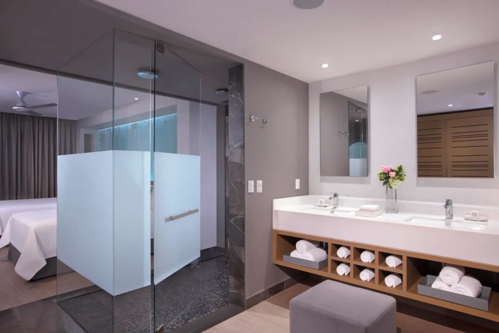 Spa-inspired bathroom in the Xcelerate Junior Suite Ocean Front at Breathless Riviera Cancun with glass-enclosed shower and double vanity.