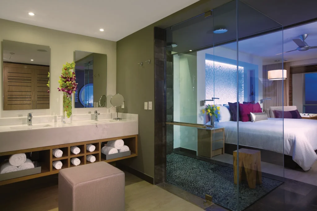 Open-concept bathroom in the Xhale Club Junior Suite Ocean Front Whirlpool at Breathless Riviera Cancun featuring a glass-enclosed rain shower, modern vanity, and upscale finishes.