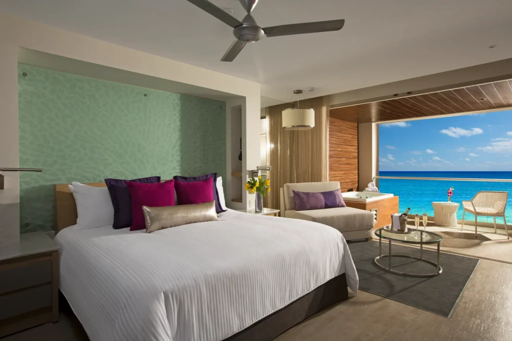 King-bed bedroom in the Xhale Club Junior Suite Ocean Front Whirlpool at Breathless Riviera Cancun with oceanfront views, modern décor, and plush bedding.