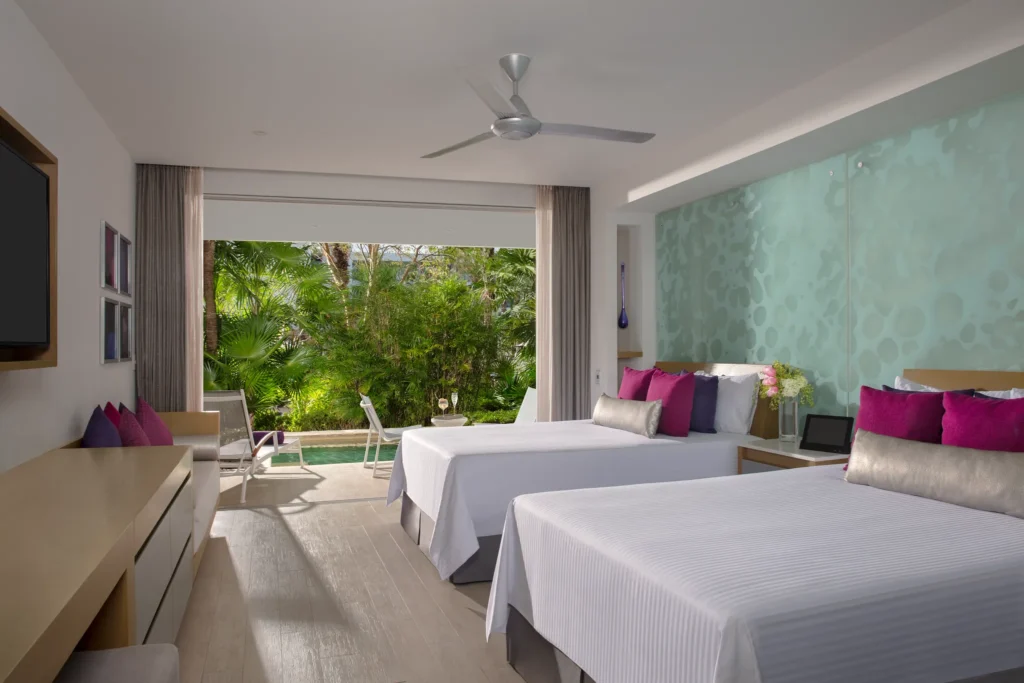 Xhale Club Junior Suite Swim Out Tropical View with double beds at Breathless Riviera Cancun, featuring pool access and tropical garden views.