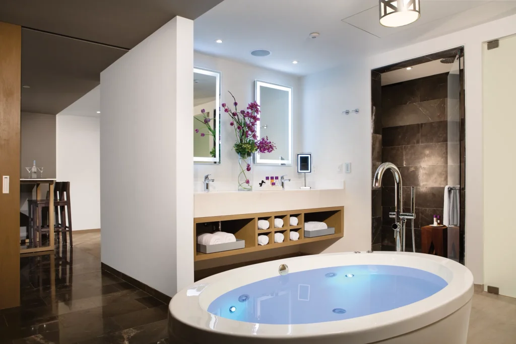 Xhale Club Master Suite Ocean Front bathroom at Breathless Riviera Cancun featuring a luxury whirlpool tub, modern double vanity, and spa-style walk-in shower.