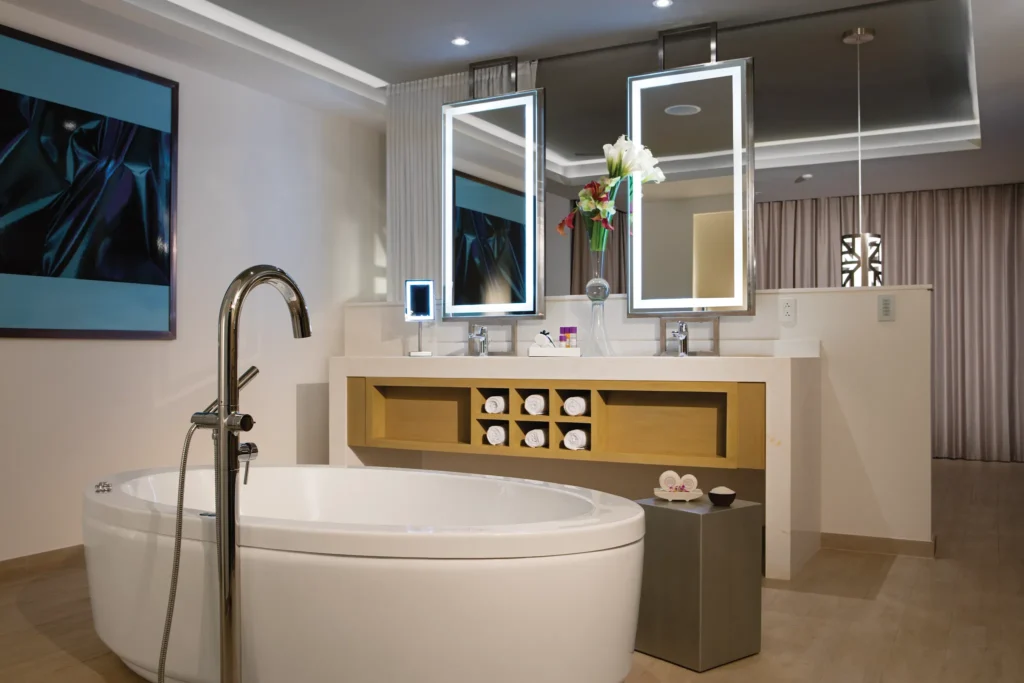 Dual vanity bathroom in the Xhale Club Presidential Suite at Breathless Riviera Cancun featuring illuminated mirrors, luxury towels, and modern spa-style décor.