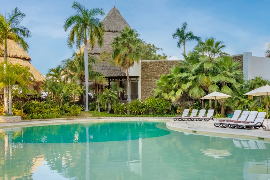 Saltwater pool with tropical landscaping and lounge chairs at Dreams Acapulco Resort & Spa.
