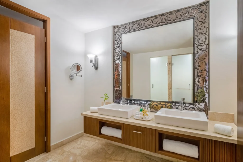 Preferred Club Deluxe Ocean View bathroom with dual sinks and decorative framed mirror at Dreams Acapulco Resort & Spa.