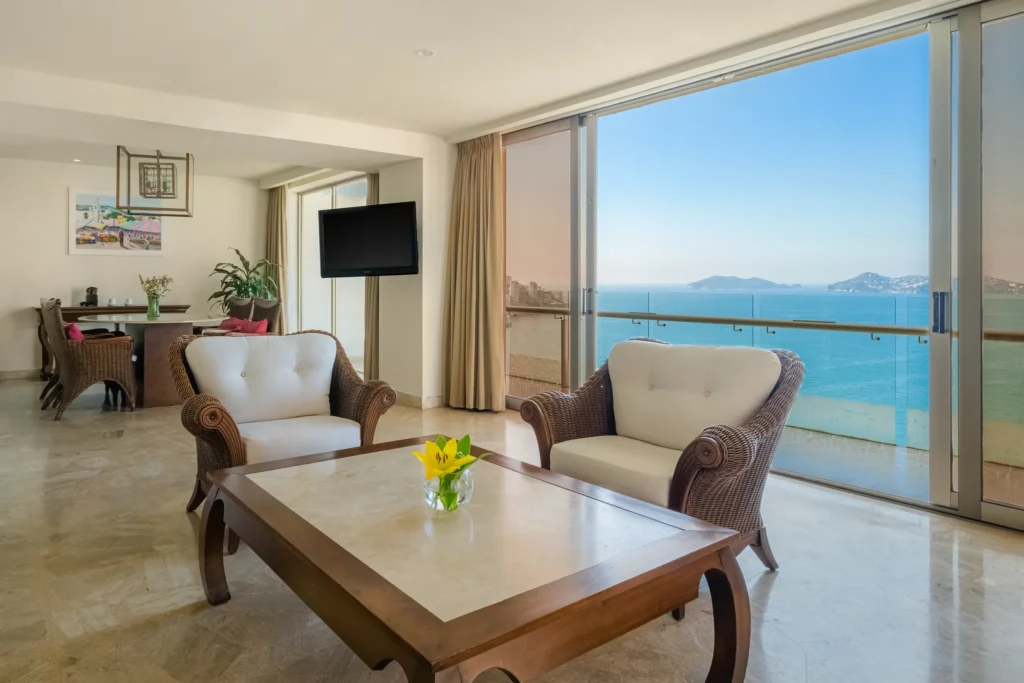 Preferred Club Junior Suite Ocean Front living area with balcony at Dreams Acapulco Resort & Spa overlooking the bay.