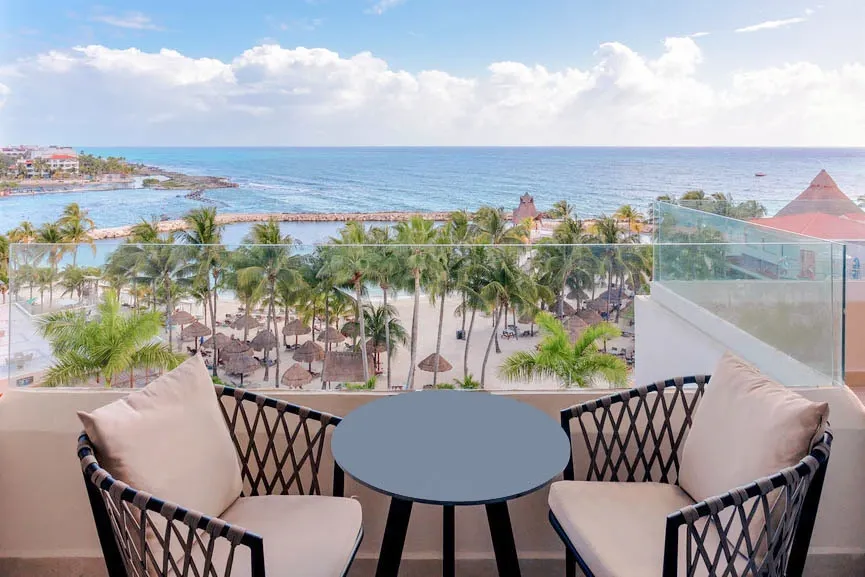 Private balcony with seating and ocean view at Deluxe Ocean View room in Dreams Aventuras Riviera Maya.