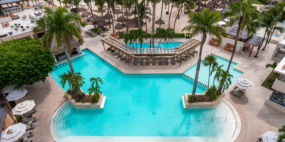 Lagoon-style natural pool venue with palm trees at Dreams Aventuras Riviera Maya