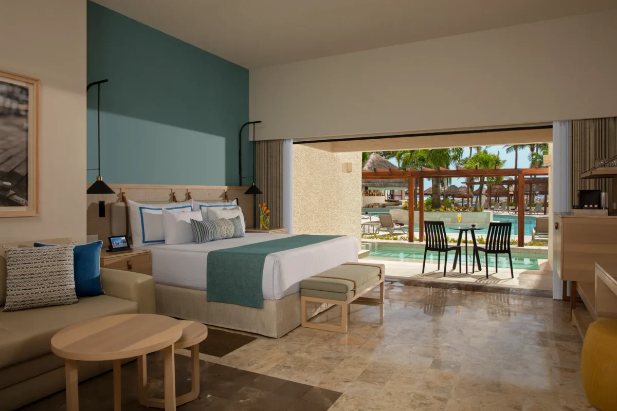Preferred Club Family Swim Out room with king bed and direct pool access terrace at Dreams Aventuras Riviera Maya.