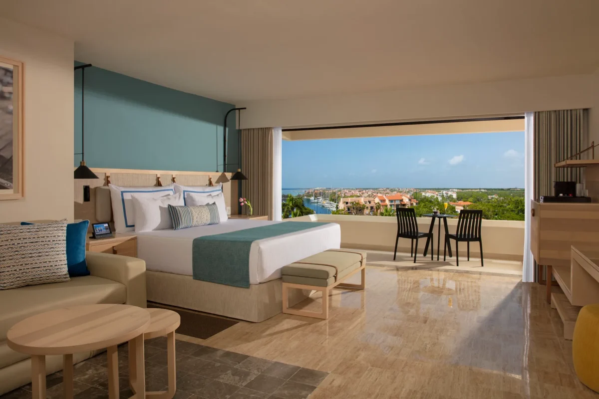 Preferred Club Marina View room with king bed and private balcony overlooking marina and sunset views at Dreams Aventuras Riviera Maya.
