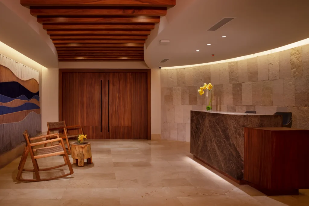 Spa reception desk with modern design and seating area at Dreams Aventuras Riviera Maya.