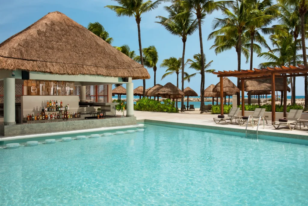 Sugar Reef pool bar at Dreams Aventuras Riviera Maya featuring a relaxed swim-up setting, tropical cocktails, and vibrant poolside atmosphere.