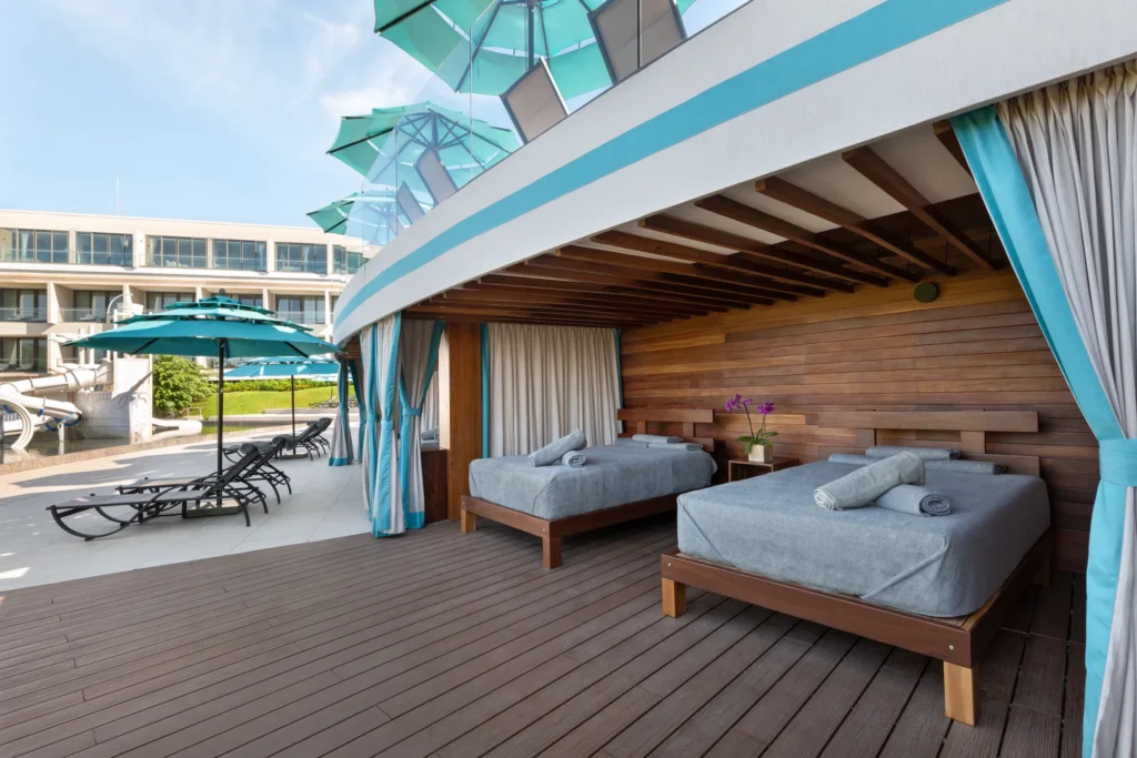 Poolside Bali beds with umbrellas and lounge chairs at Dreams Bahia Mita resort.