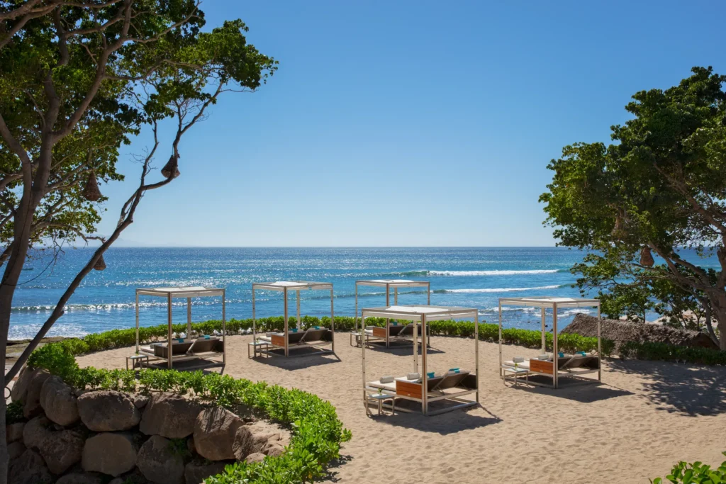 Beach cabanas and loungers overlooking the ocean at Dreams Bahia Mita beachfront terrace.