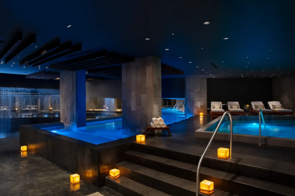 Indoor hydrotherapy pools with ambient lighting at Dreams Bahia Mita spa.
