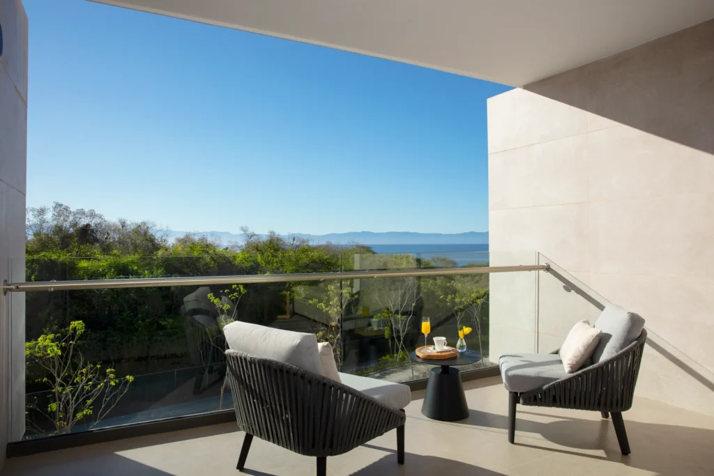 Private balcony with lounge chairs and tropical ocean view at Junior Suite Tropical View Dreams Bahia Mita Surf & Spa Resort.