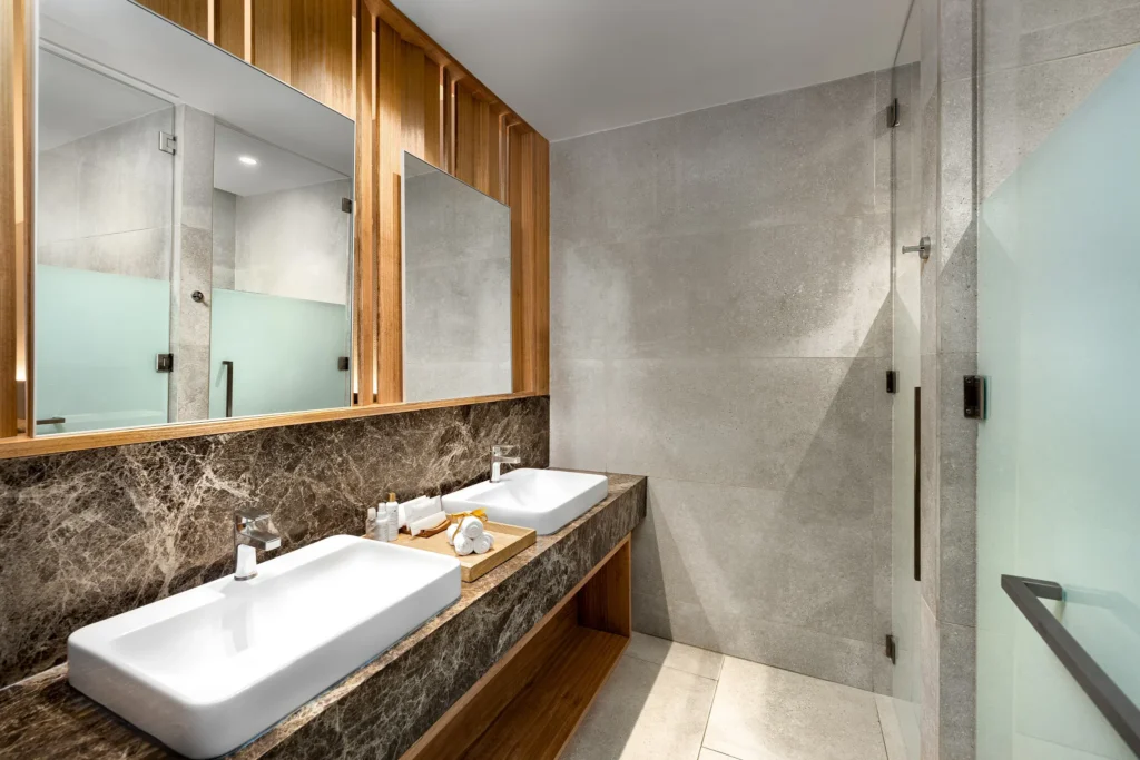 Junior Suite Tropical View bathroom with double sinks and glass rain shower at Dreams Bahia Mita Surf & Spa Resort.