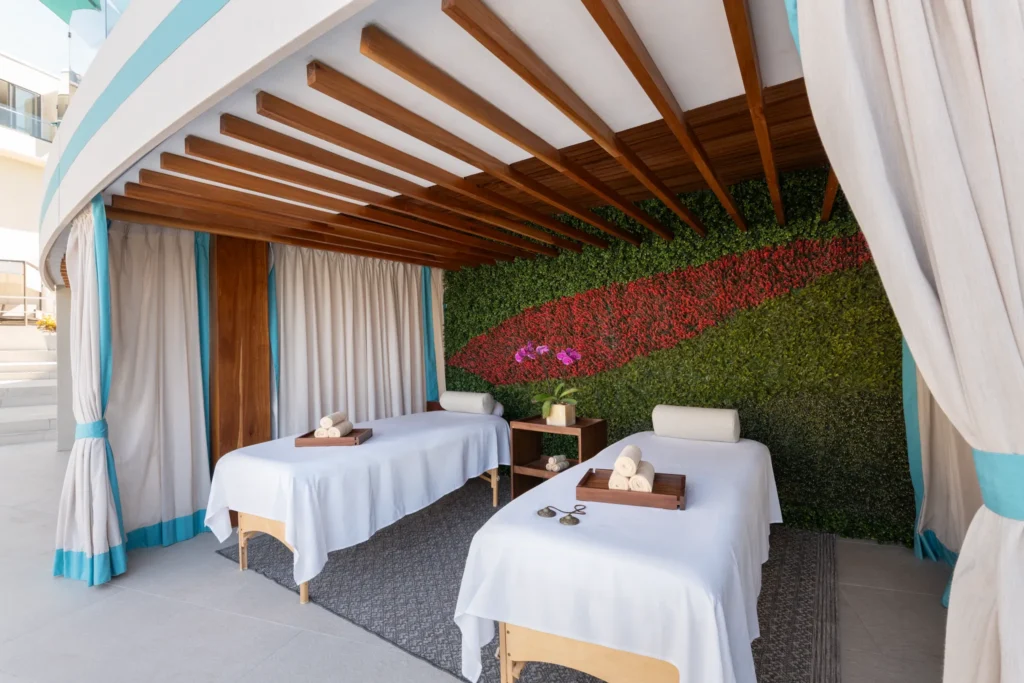 Outdoor spa cabana with massage beds and greenery wall at Dreams Bahia Mita.