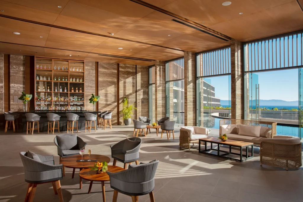 Elegant open-air lobby bar with ocean views and modern seating at Dreams Bahia Mita, perfect for relaxing drinks.