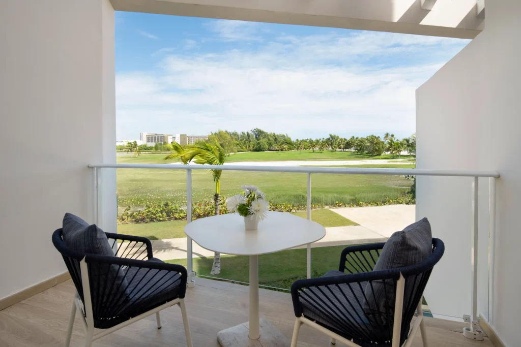 Private balcony with seating and garden views at Deluxe Garden View room in Dreams Cap Cana Resort & Spa.