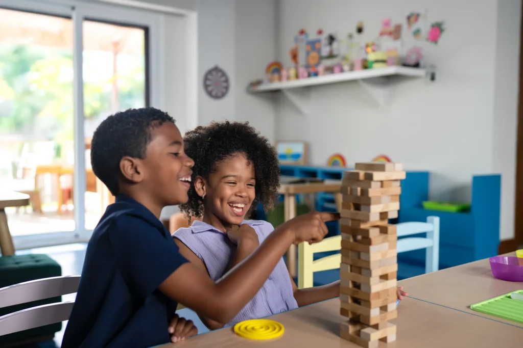 Children playing a stacking block game inside the Explorer’s Club at Dreams Cap Cana Resort & Spa.
