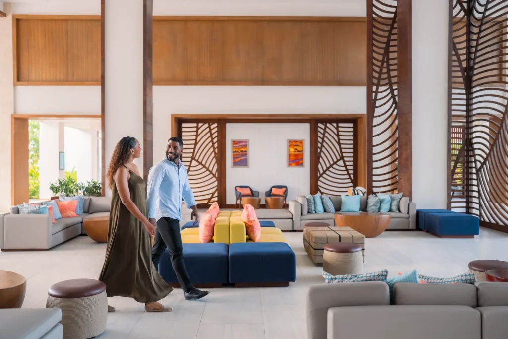 Couple walking through the elegant open-air lobby at Dreams Cap Cana Resort & Spa.