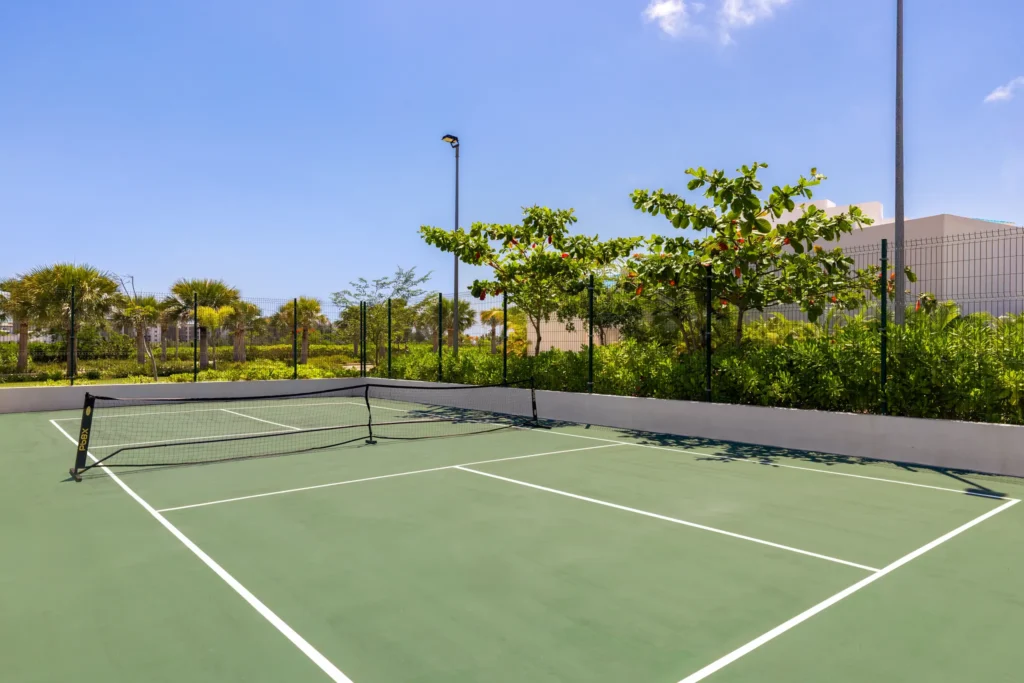 Outdoor pickleball court surrounded by greenery at Dreams Cap Cana Resort & Spa.