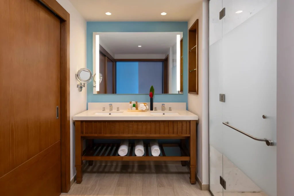 Garden View room bathroom with double sinks and walk-in rain shower at Dreams Cap Cana Resort & Spa.
