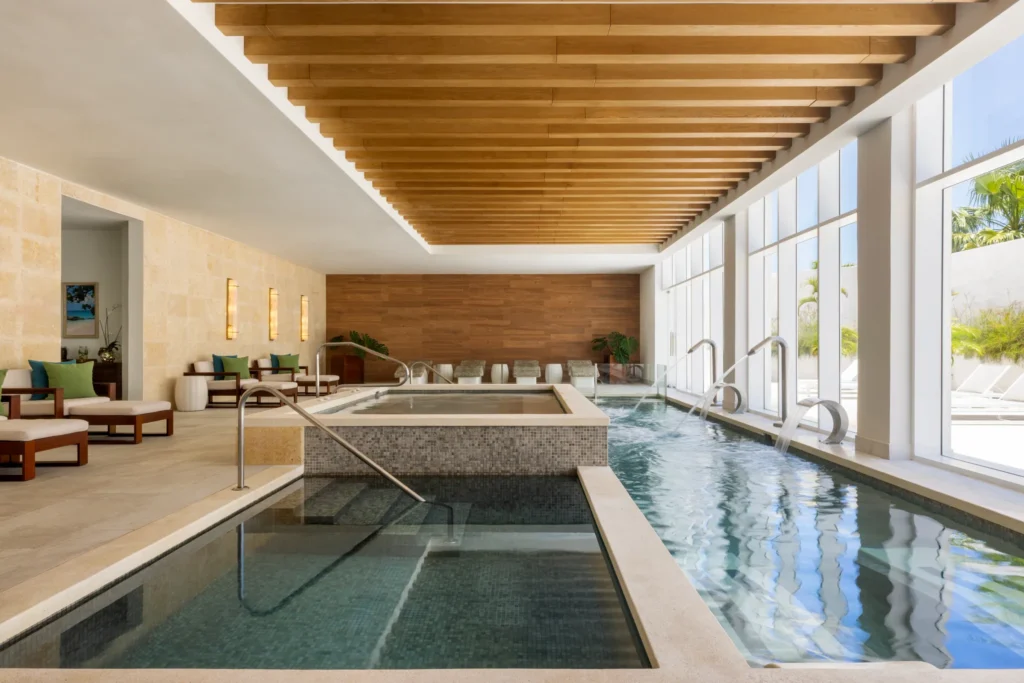 Indoor hydrotherapy pools with lounge seating at Dreams Cap Cana Resort & Spa spa.