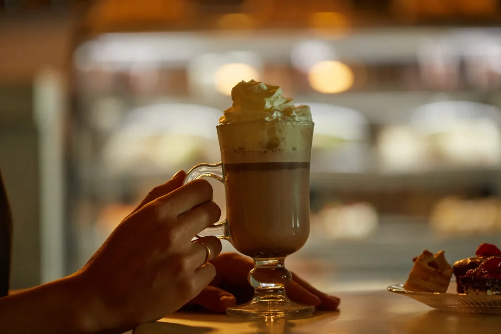 Coco Café at Dreams Cozumel Cape Resort & Spa serving premium coffee drinks, whipped cream-topped latte, pastries, and desserts in a cozy setting.