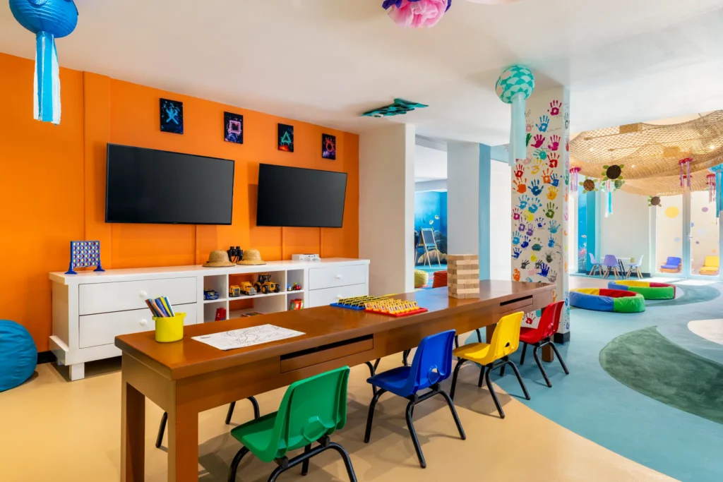 Colorful indoor kids club at Dreams Cozumel Cape Resort & Spa featuring craft tables, games, and supervised activities for children.