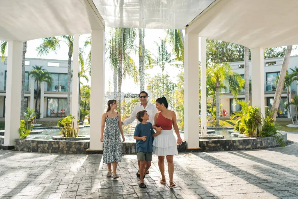 Family walking through the open-air lobby entrance at Dreams Cozumel Cape Resort & Spa.
