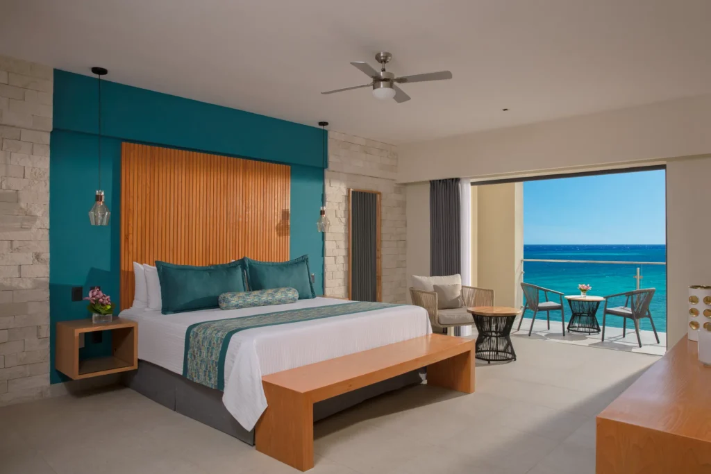 Master Suite Ocean View bedroom with king bed and balcony at Dreams Cozumel Cape Resort & Spa.