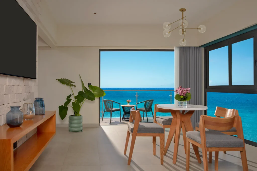 Master Suite Ocean View living and dining area with balcony access at Dreams Cozumel Cape Resort & Spa.