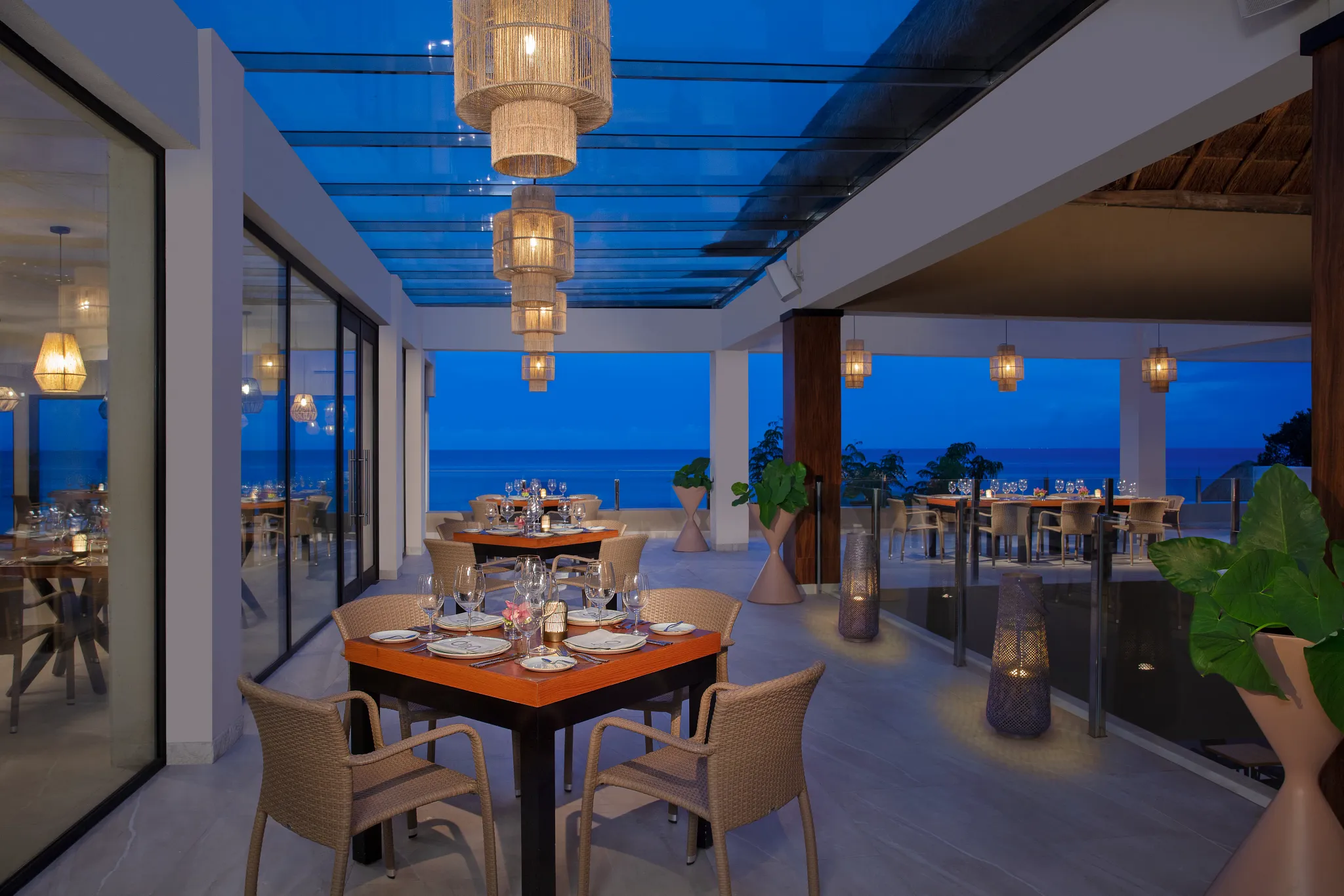 Olio Mediterranean restaurant at Dreams Cozumel Cape Resort & Spa featuring elegant terrace dining with ocean views at sunset.