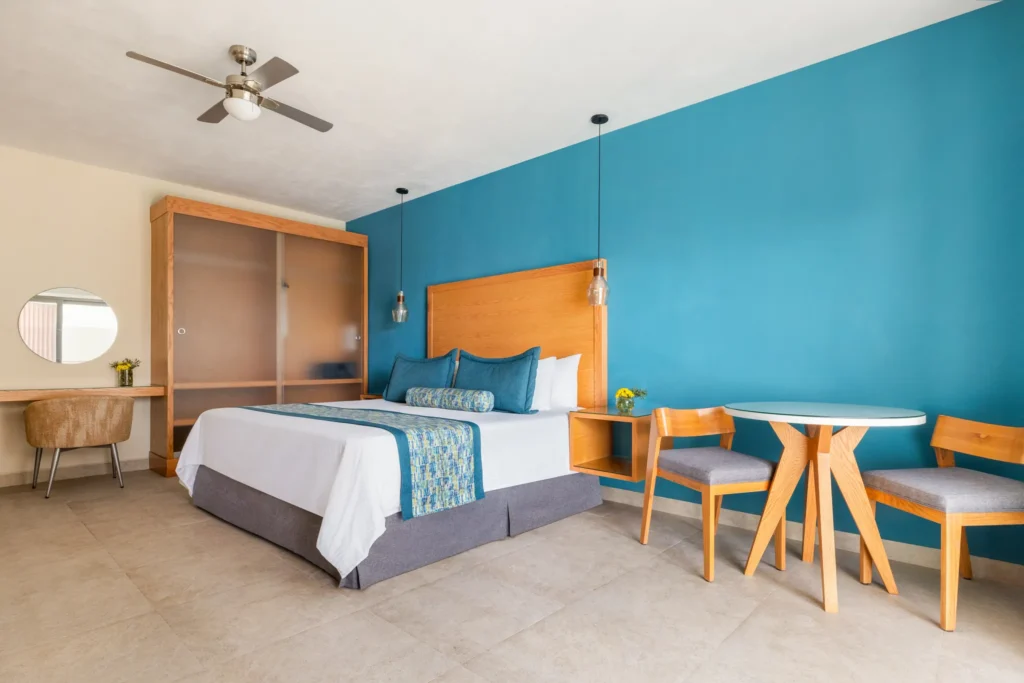 Preferred Club Junior Suite King with modern wood furnishings and resort views at Dreams Cozumel Cape Resort & Spa.