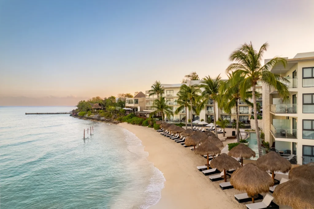 Private beach with loungers and palapas at Dreams Cozumel Cape Resort & Spa.