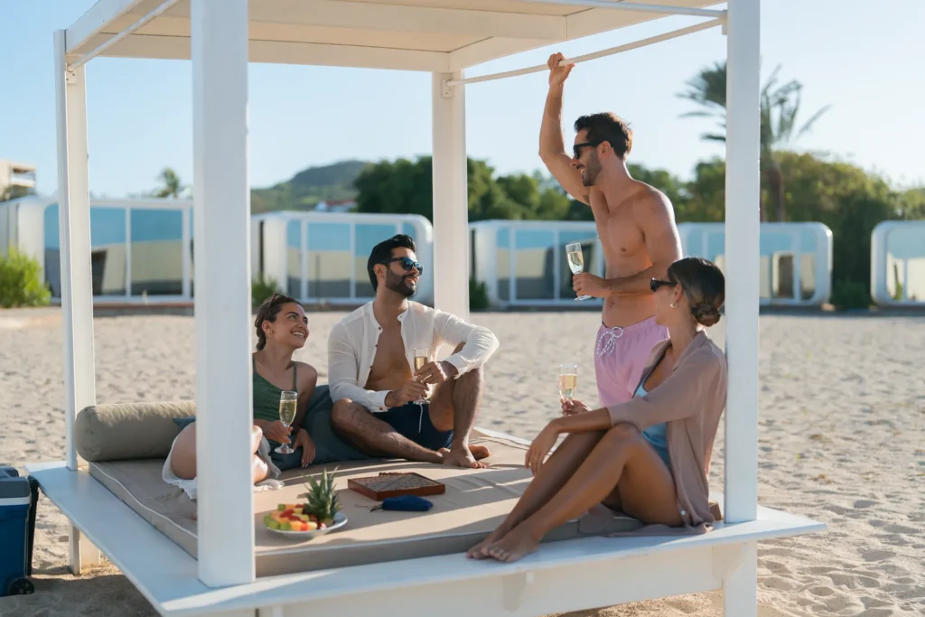 Friends relaxing with champagne in a beachfront cabana at Dreams Curaçao Resort.