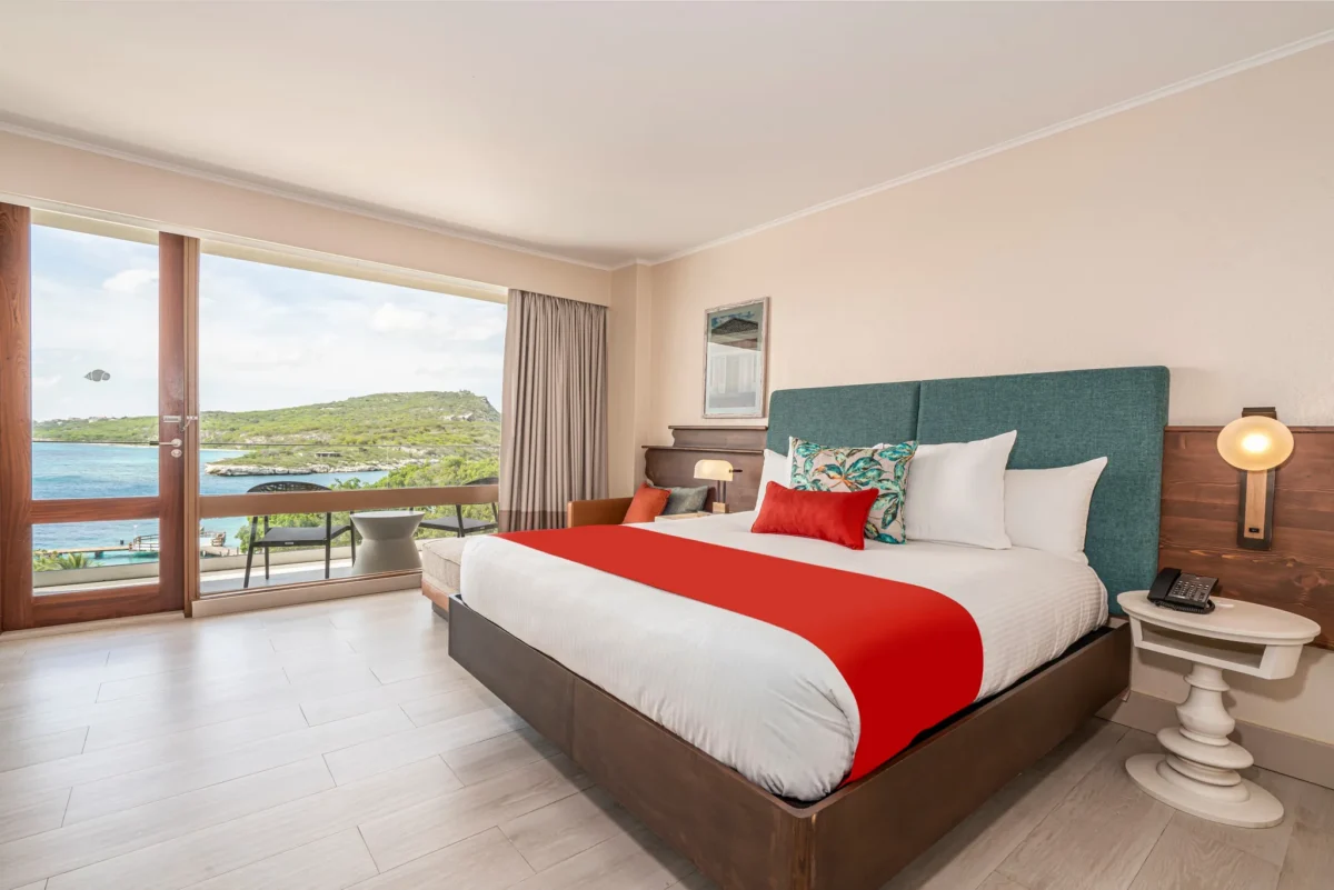 Deluxe Ocean View room with king bed and private balcony overlooking the Caribbean Sea at Dreams Curaçao Resort.