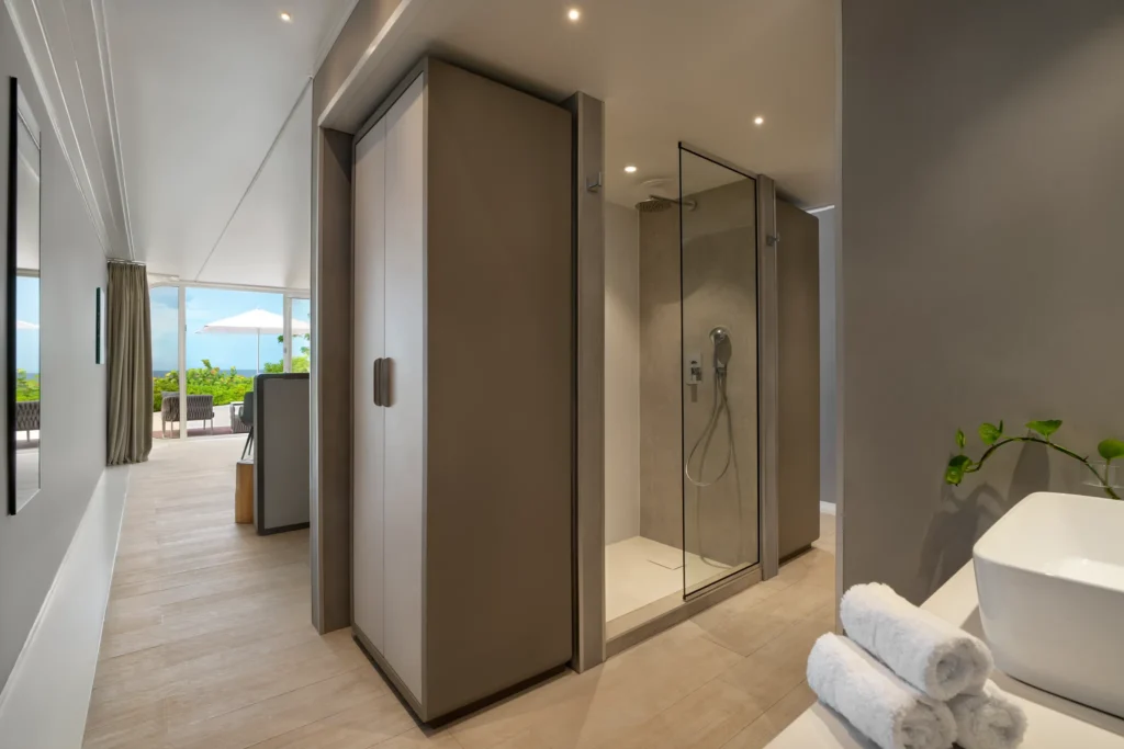 Walk-in glass shower in beachfront bungalow bathroom at Dreams Curaçao Preferred Club.