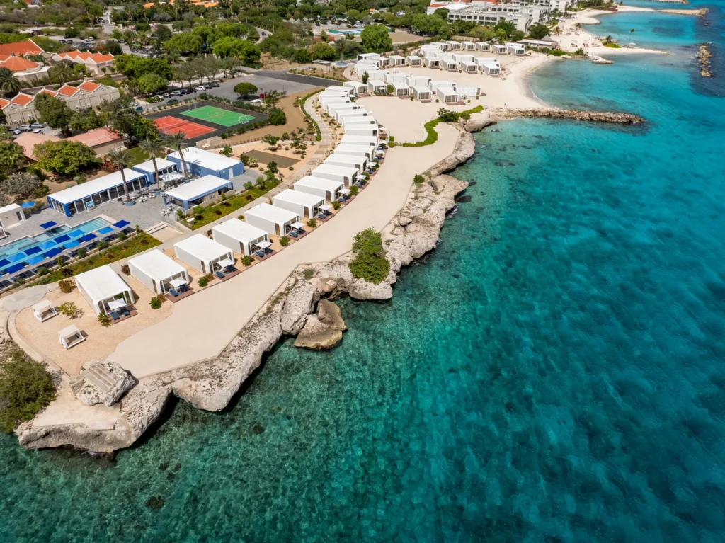 Close aerial view of beachfront cabanas and turquoise water at Dreams Curaçao Mare section.