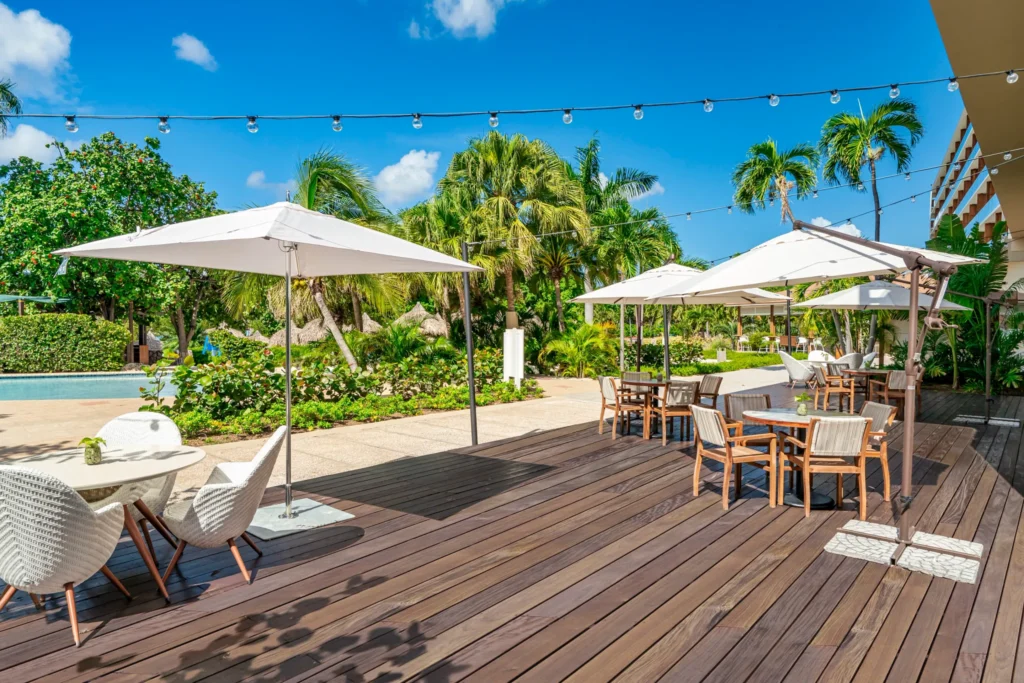 Outdoor terrace dining area with umbrellas and tropical landscaping at Dreams Curaçao Resort.